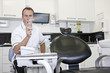 A male dentist in his surgery testing a dental drill