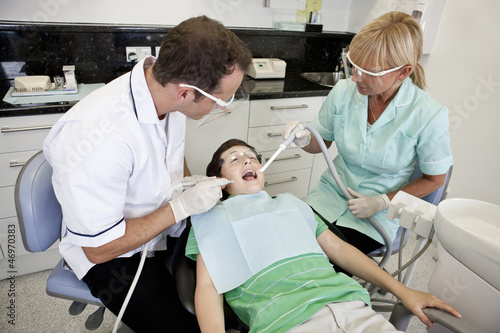 Photo: A young boy patient having dental treatment, looking scared A young boy patient having dental treatment, looking scared
