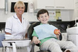 A young boy at the dentist holding an apple