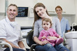 A male dentist with a little girl patient and her mother