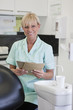 A female dental nurse holding patient dental records