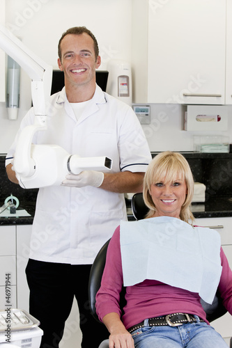 Photo: A male dentist with a female patient in his surgery A male dentist with a female patient in his surgery