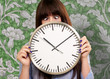 Photo: Woman Holding Clock With Squinted Eyes Woman Holding Clock With Squinted Eyes