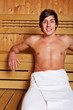 Junger Mann sitzt in Sauna