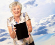 Foto: Portrait Of A Senior Woman Holding A Digital Tablet Portrait Of A Senior Woman Holding A Digital Tablet