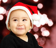Baby boy smiling and wearing a christmas hat