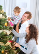 Young Family decorating a Christmas Tree