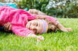 Happy little girl lying on grass