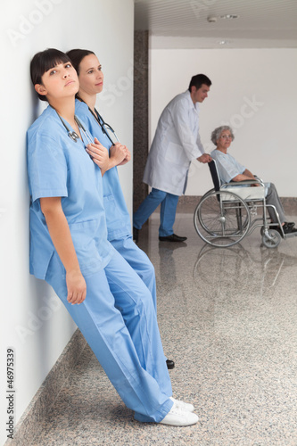 Photo: Two nurses leaning on wall Two nurses leaning on wall