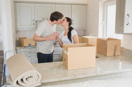 Photo: Happy couple kissing in the kitchen Happy couple kissing in the kitchen
