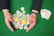 Hands grabbing dollars and chips from table beside royal flush