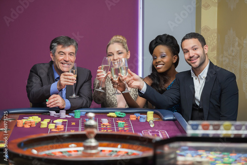 Photo: Four people toasting with champagne at roulette Four people toasting with champagne at roulette
