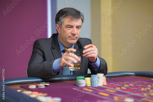 Photo: Man looking at the roulette table looking angry Man looking at the roulette table looking angry