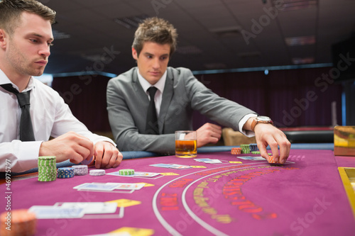 Photo: Man placing bet in poker game Man placing bet in poker game