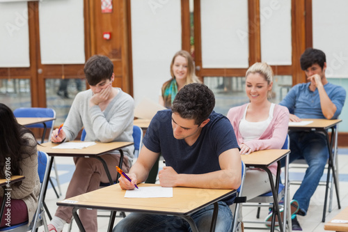 Photo: Students sitting at the exam room writing Students sitting at the exam room writing