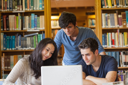 Photo: Students watching something on laptop in library Students watching something on laptop in library