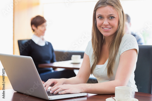 Photo: Student sitting at the coffee shop with laptop Student sitting at the coffee shop with laptop