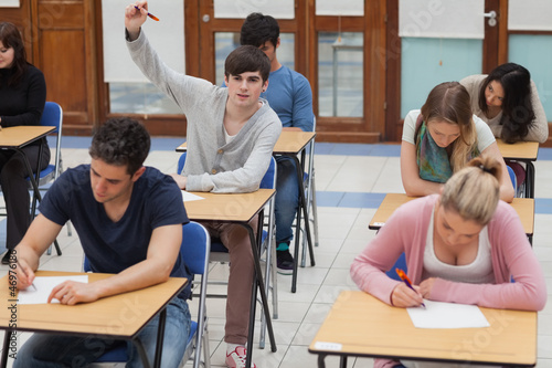 Photo: Boy raising hand during exam Boy raising hand during exam