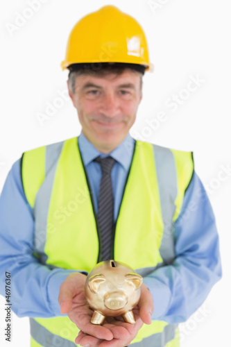 Photo: Architect holding a piggy bank Architect holding a piggy bank
