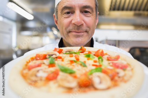 Photo: Chef showing a pizza Chef showing a pizza