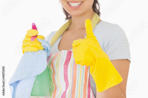 Photo: Woman giving thumbs up holding cleaning products Woman giving thumbs up holding cleaning products