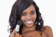 Photo: Woman smiling while holding a makeup brush Woman smiling while holding a makeup brush