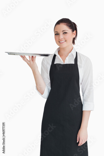 Photo: Smiling woman holding an empty silver tray Smiling woman holding an empty silver tray