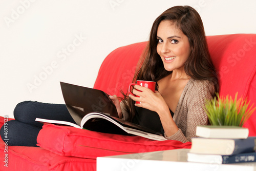 Photo: Schöne Frau liegt gemütlich auf der Couch Schöne Frau liegt gemütlich auf der Couch