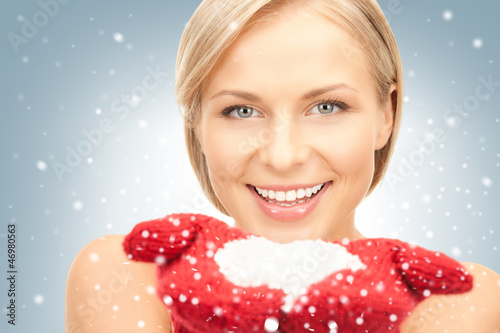Photo: beautiful woman in red mittens with snow beautiful woman in red mittens with snow