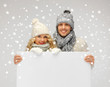 couple in a winter clothes holding blank board