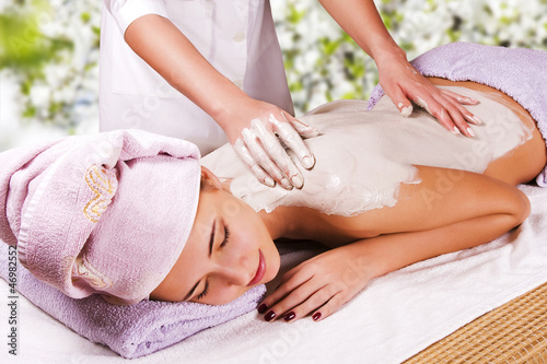 Photo: Young woman with slimming body thermal mask on her back. Spa Tre Young woman with slimming body thermal mask on her back. Spa Tre