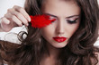 Glamour portrait of beautiful woman with red lips and feather