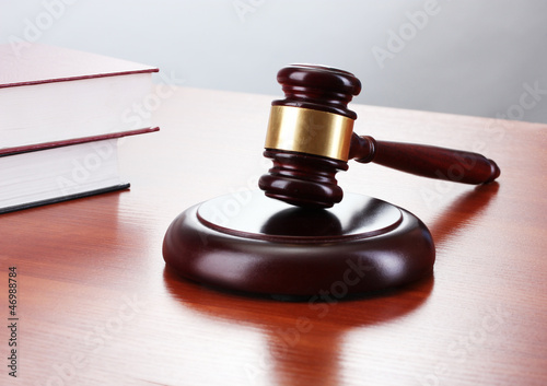 Photo: gavel and books on wooden table on gray background gavel and books on wooden table on gray background