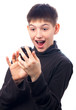 Cute surprised teenage boy looking at his smart phone