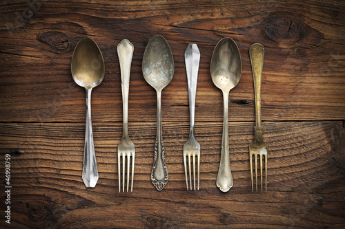 Photo: Old forks and spoons on wooden background Old forks and spoons on wooden background