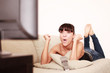 Frau jubelnd vor dem Fernseher