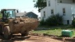 Bulldozer Dumping Dirt in Truck Bed