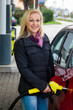 Frau beim tanken auf Tankstelle