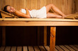 Foto: Young woman relaxing in a sauna Young woman relaxing in a sauna