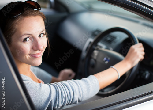 Photo: Pretty young woman driving her new car Pretty young woman driving her new car