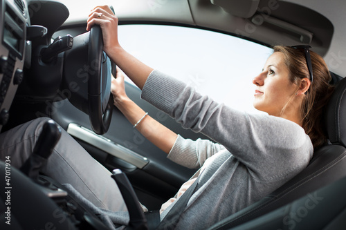 Photo: Pretty young woman driving her new car Pretty young woman driving her new car