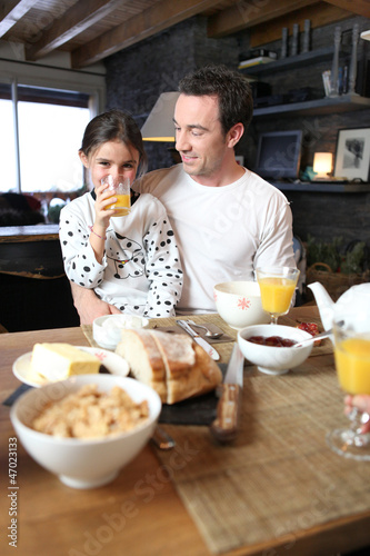 Photo: Man and little girl having breakfast Man and little girl having breakfast