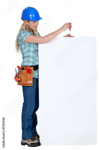 Photo: craftswoman fixing an ad board craftswoman fixing an ad board