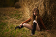 Pretty girl resting on straw bale