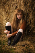 Pretty girl resting on straw bale