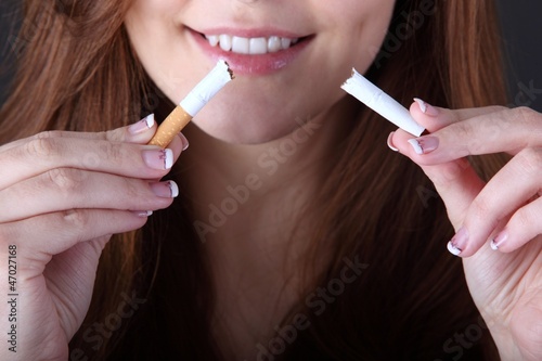 Photo: woman and stop smoking cigarette (focus on cigarette) woman and stop smoking cigarette (focus on cigarette)