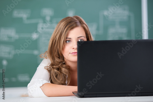 Photo: schülerin schaut auf auf einen laptop schülerin schaut auf auf einen laptop