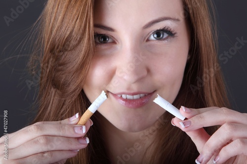 Photo: woman and stop smoking cigarette (focus on cigarette) woman and stop smoking cigarette (focus on cigarette)