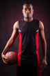 Portrait of a young male basketball player against black backgr