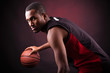 Foto: Portrait of a young male basketball player against black backgr Portrait of a young male basketball player against black backgr